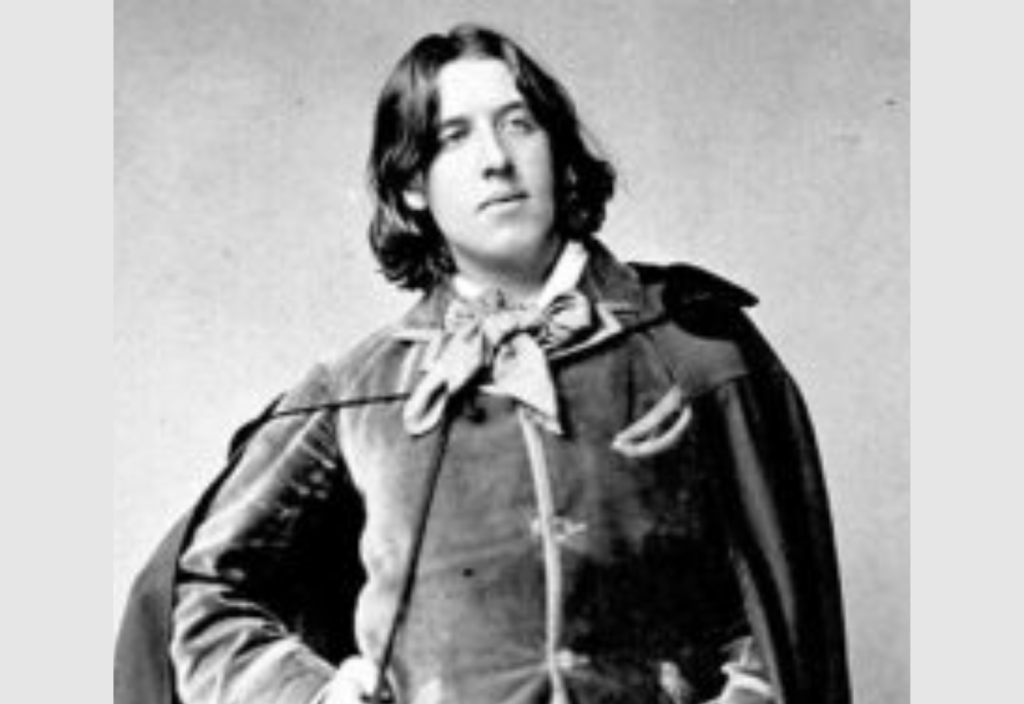 Oscar Wilde posing in a cloak