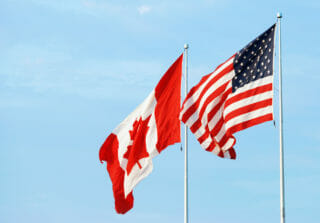 American flag and Canadian flag blowing