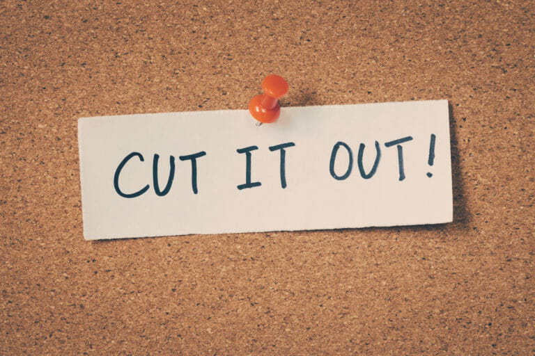 cut it out sign pinned to cork board