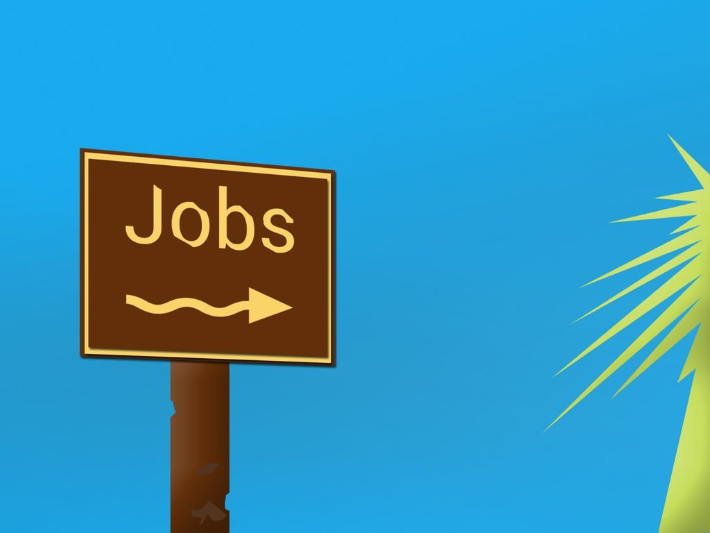 directions to jobs sign pointing to a green palm tree